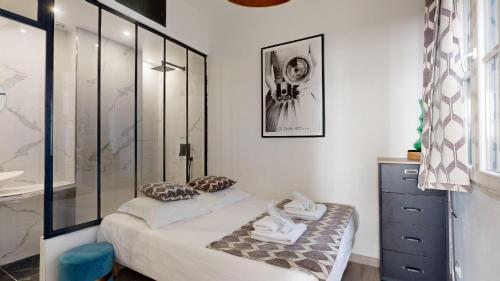- une petite chambre avec un lit et une douche en verre dans l'établissement Bluestay 13 - Charmant appartement à Paris, à Paris