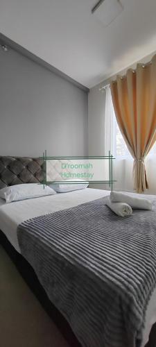 a bedroom with a large bed with a window at D'roomah Homestay in Sepang
