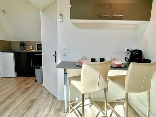 une cuisine avec une table et des chaises dans une pièce dans l'établissement Chez Léon - Calme & Lumière, à Reims