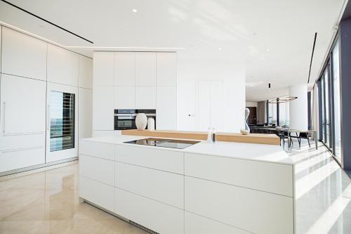 a kitchen with white cabinets and a large island at Nicosia Central Park Residences in Nicosia