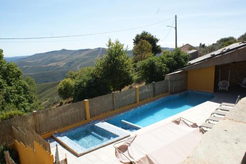 a swimming pool with two chairs and a fence at O Bolaño Apt 2 in Parada de la Sierra