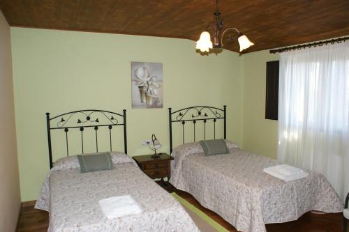 a bedroom with two beds and a chandelier at O Bolaño Apt 2 in Parada de la Sierra