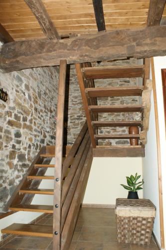 a wooden staircase in a room with a brick wall at O Bolaño Apt 2 in Parada de la Sierra