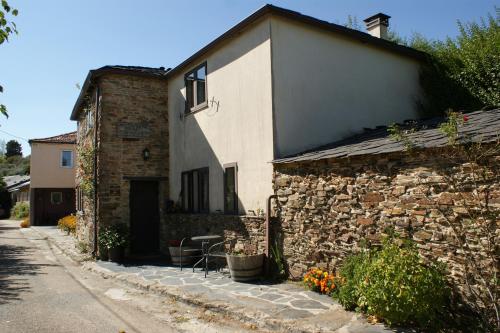 a stone house with a stone wall next to a building at O Bolaño Apt 1 in Parada de la Sierra