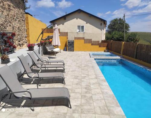 a group of lounge chairs next to a swimming pool at O Bolaño Apt 1 in Parada de la Sierra
