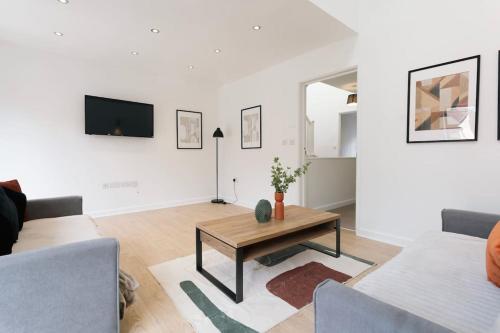 a living room with a table and a tv at Central Cambourne Place Retreat in Gateshead