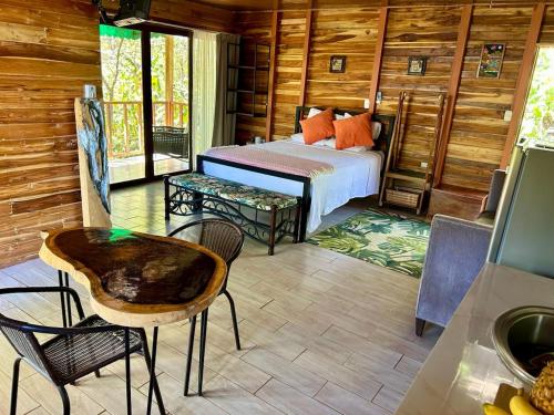 a bedroom with a bed and a table and chairs at Cabañas Los Jobos in Villarreal