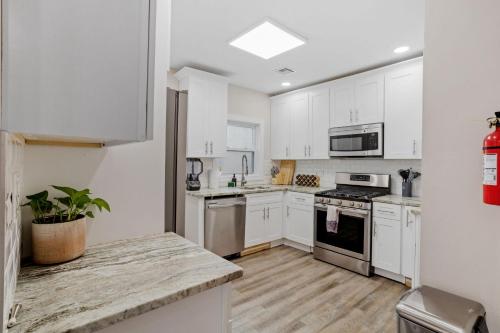 a kitchen with white cabinets and white appliances at Beautifully Renovated 6BR 2BA 2 Blocks to Beach in Atlantic City