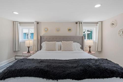 a bedroom with a large bed with two windows at Beautifully Renovated 6BR 2BA 2 Blocks to Beach in Atlantic City