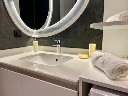 a bathroom with a sink and a large mirror at Via Mar Residence - Alanya Experience in Alanya