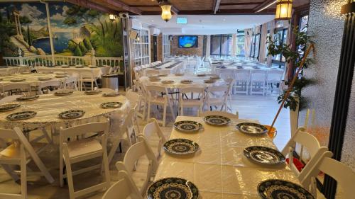 a dining room with white tables and white chairs at Hotel Alma - Near The Sea in Netanya
