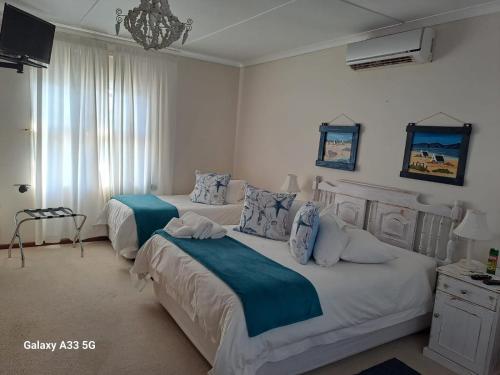 a bedroom with two beds and a chandelier at The Golden Grape B&B in Lutzville