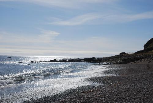 a beach with a rocky shore and the ocean at Faodail 'a lucky find' in Dunbeath