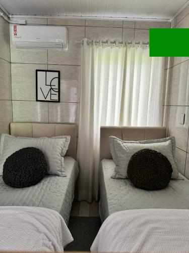 a bedroom with two beds and a window at Granbalaio Hostel in Blumenau