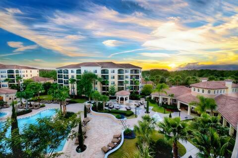 a resort with a pool and palm trees and buildings at Entire Rental 3-BR Minutes from Disney x8 Hot tub Apartment 2204 in Orlando