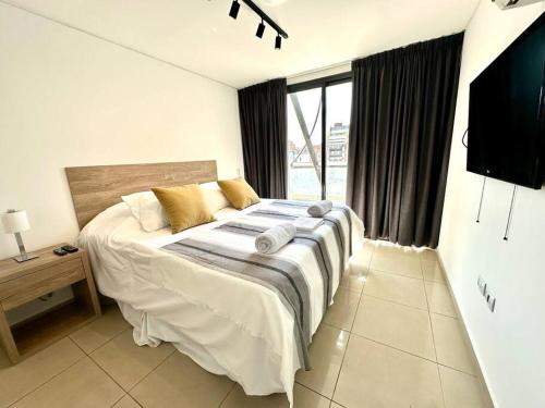 a bedroom with a large bed and a television at Departamento para 6 personas in Cordoba