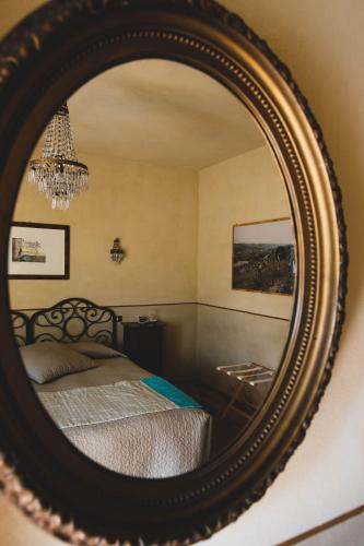 a bedroom with a bed and a mirror at L'Atelier di Pierflavio Gallina in La Morra