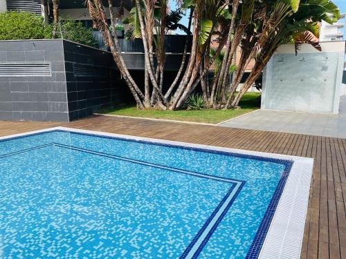 einem blauen Pool vor einem Gebäude in der Unterkunft Paraiso de costa in Playa de Gandia