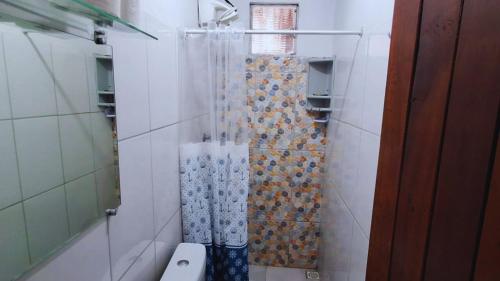 a bathroom with a toilet and a shower curtain at Vila dos Bangalôs in Barreirinhas