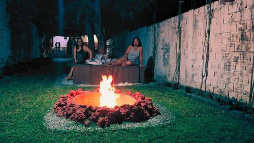 a group of people sitting around a fire in the grass at Vila dos Bangalôs in Barreirinhas