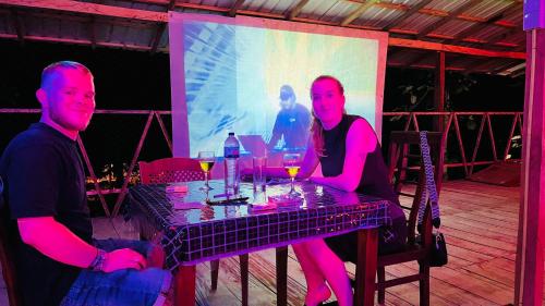 a man and woman sitting at a table with wine glasses at Sigiriya Green Garden Home in Sigiriya