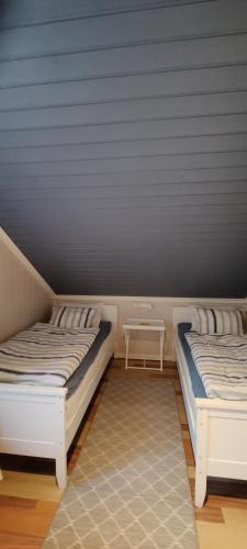 a room with two beds and a table in it at Øya husrom 2 in Sarpsborg
