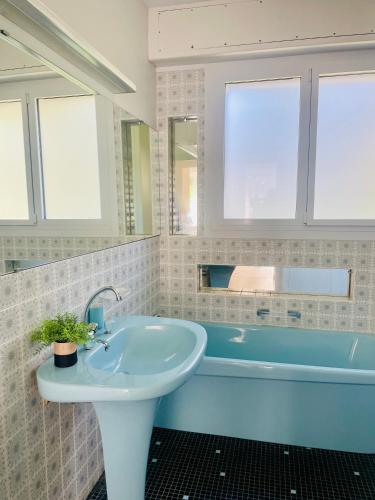 une salle de bain avec un lavabo et une baignoire dans l'établissement Villa Topaze à La Baule, à Mazy
