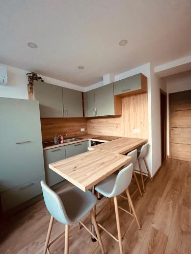une cuisine avec une table et des chaises en bois dans l'établissement appartement terrasse Roof Top climatisé, à Gaillac
