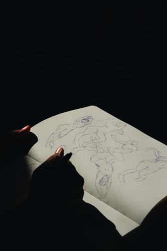 a person is reading a book with a drawing on it at L'Atelier di Pierflavio Gallina in La Morra