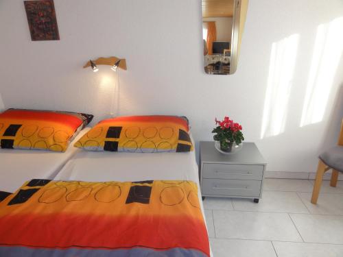 een slaapkamer met 2 bedden en een tafel met bloemen bij Apartment Beck in Wilderswil