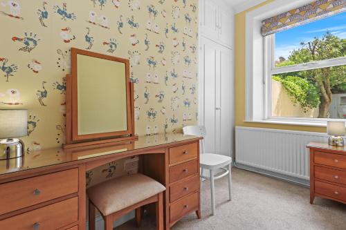 イーストボーンにあるBay Tree Apartmentのベッドルーム1室(鏡付きドレッサー、窓付)