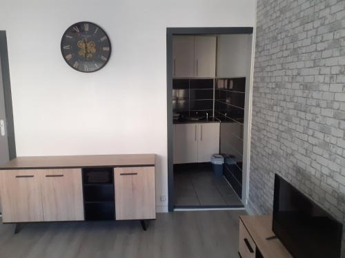 une chambre avec une horloge au mur et une cuisine dans l'établissement Charmant studio bien équipé, à Banyuls-dels-Aspres