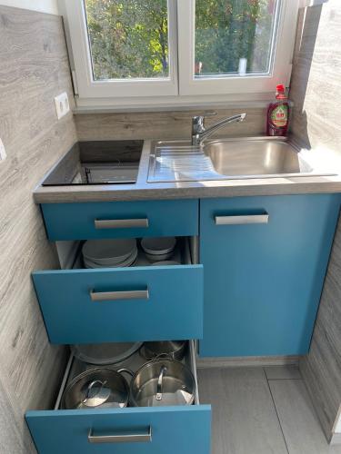 a kitchen with blue drawers and a sink at hochwertiges Studio in bester Lage in Friedrichshafen