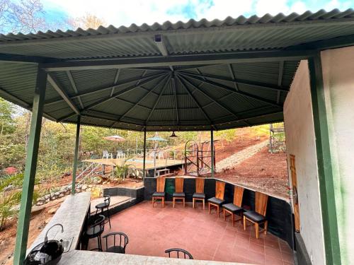 a patio with a table and chairs under an umbrella at Cabañas Los Jobos in Villarreal
