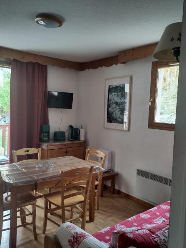 une salle à manger avec une table et des chaises en bois dans l'établissement Puy St Vincent 1800 - appt 6 pers - près des pistes, à Puy-Saint-Vincent