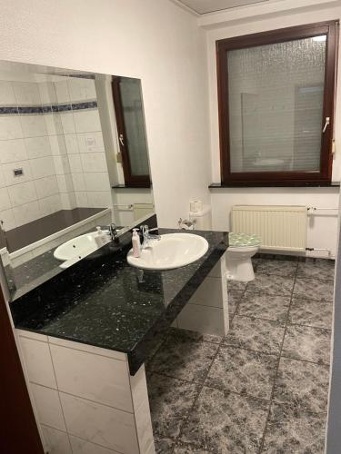 a bathroom with a black counter and a sink at Pension Hoffmann in Wuppertal