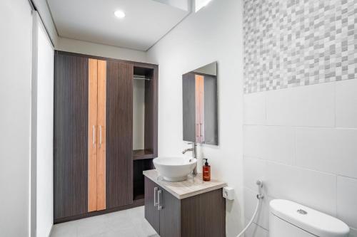 a bathroom with a sink and a toilet at Cove Arganta in Dalung