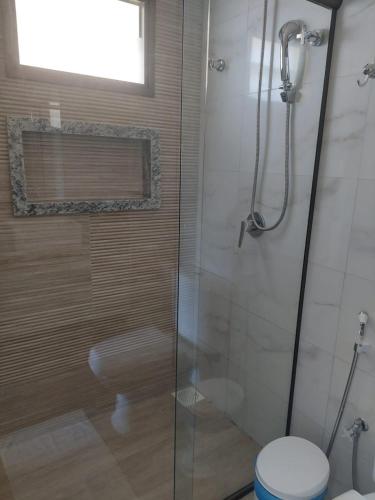 a bathroom with a shower with a toilet and a window at Flecheiras in Trairi