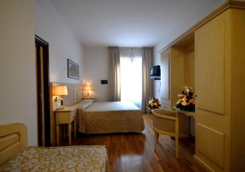 a hotel room with a bed and a desk at Grand Hotel Duomo in Pisa