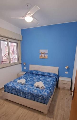 a blue bedroom with a bed with two towels on it at Appartamento Galatea mare in SantʼAlessio Siculo