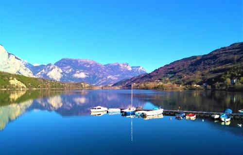a group of boats docked on a lake with mountains at Le Betulle in Vezzano