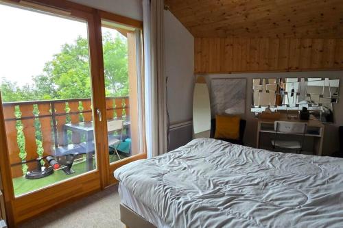 une chambre avec un lit et un balcon dans l'établissement Les Spatules, à Thollon-les-Mémises