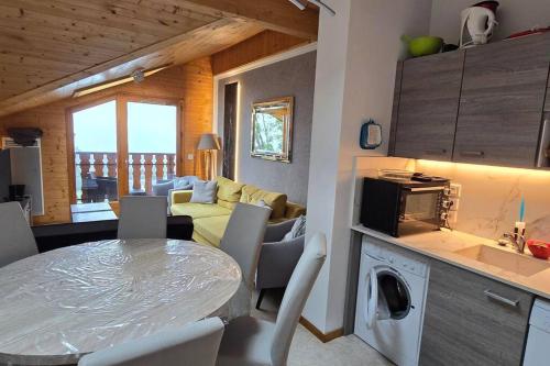 une cuisine et un salon avec une table et des chaises dans l'établissement Les Spatules, à Thollon-les-Mémises