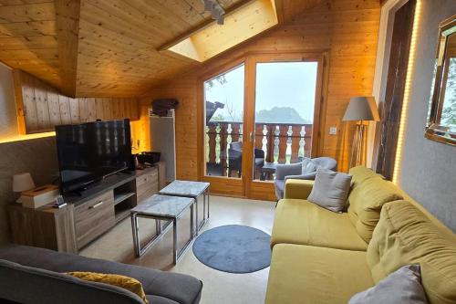 un salon avec un canapé et une télévision dans l'établissement Les Spatules, à Thollon-les-Mémises