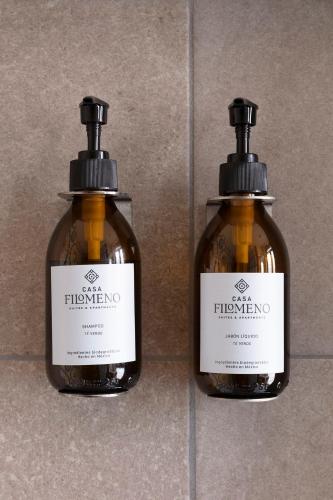 two bottles of shampoo sitting on a tile floor at Casa Filomeno in Mexico City