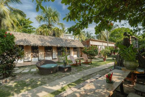 a house with a thatched roof and a patio at Finca Escondida in Palomino