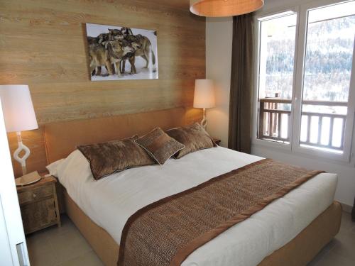 une chambre avec un lit et une grande fenêtre dans l'établissement La détente, vues, espaces le tout dans une décoration superbe, à Auron