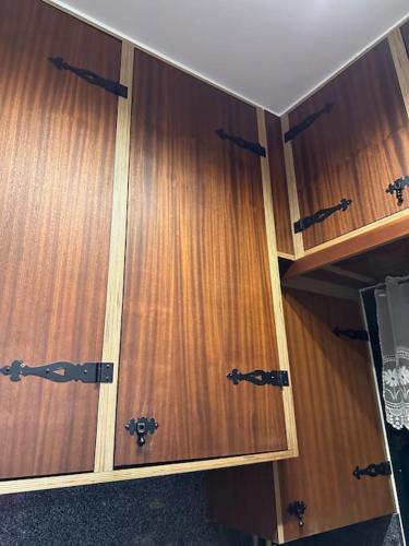 a pair of wooden cabinets with black handles at House in Camara de Lobos in Estreito de Câmara de Lobos