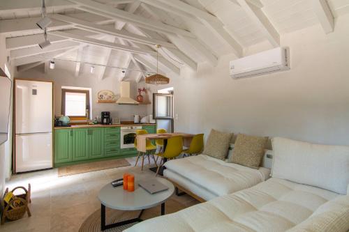 a living room with a white couch and a kitchen at olive grove by the sea 30m from the beach in Kardamili
