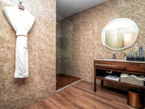 a bathroom with a sink and a mirror at CIKA GOLDEN HOTEL and SUITES in Lomé